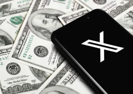 Smartphone displaying the X logo on U.S. dollar bills, illustrating X Money digital banking services nationwide.