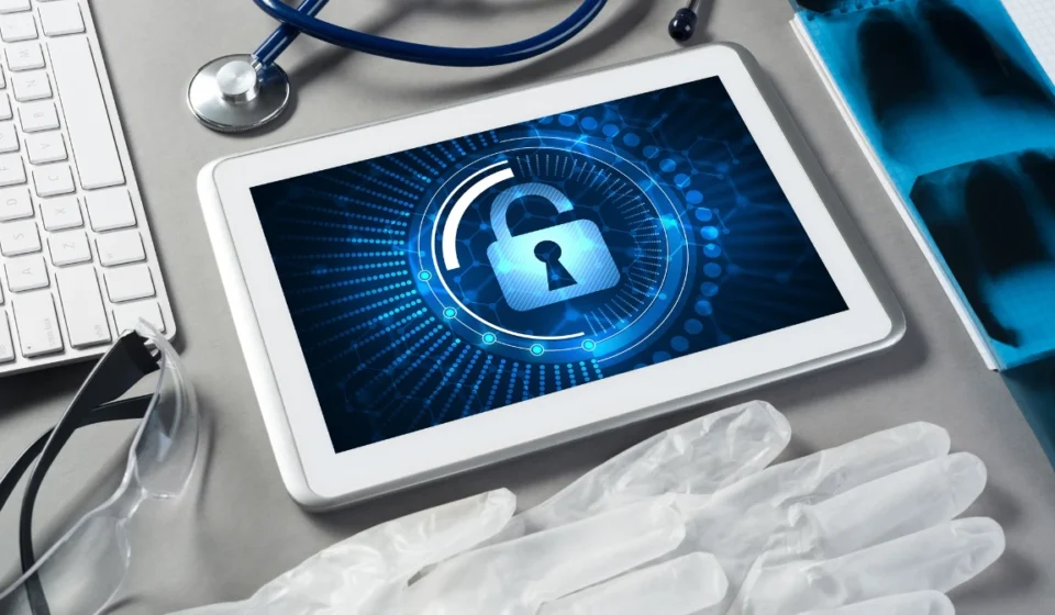 Tablet displaying healthcare cybersecurity lock beside medical tools, highlighting secure systems AI