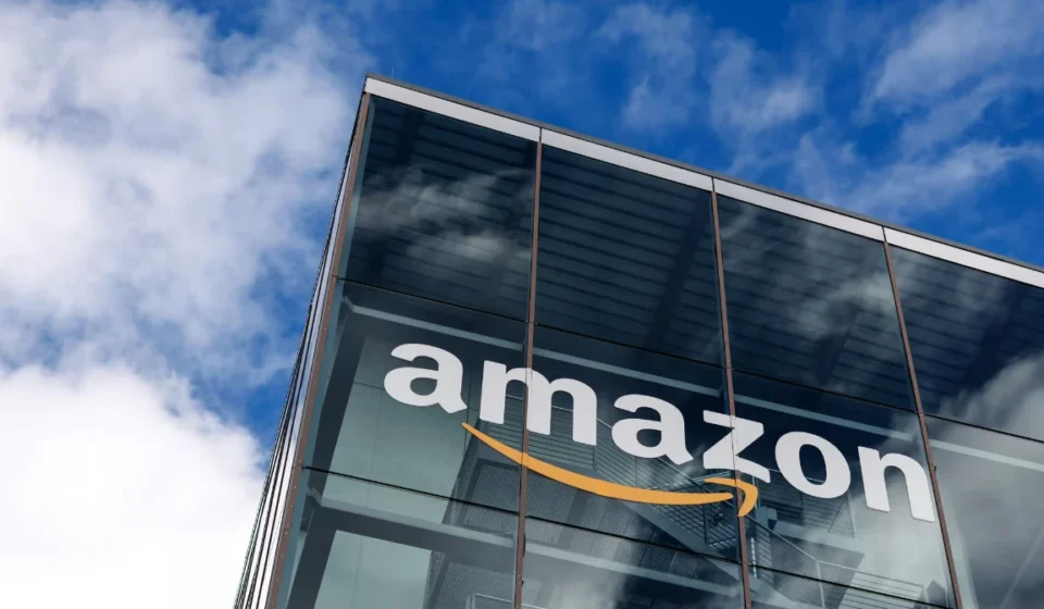 Amazon logo displayed on a modern glass office building as company expands satellite connectivity AI