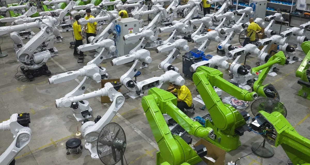 China factory workers assembling industrial robotic arms for AI driven advanced manufacturing production lines.