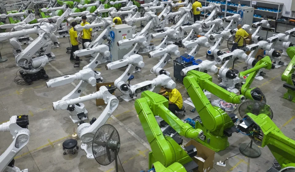 China factory workers assembling industrial robotic arms for AI driven advanced manufacturing production lines.