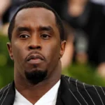 Sean Combs in a black pinstripe suit at a public event before reported prison altercation developments.