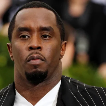 Sean Combs in a black pinstripe suit at a public event before reported prison altercation developments.