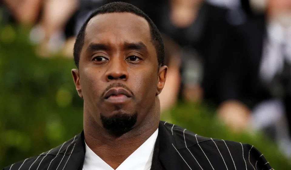 Sean Combs in a black pinstripe suit at a public event before reported prison altercation developments.