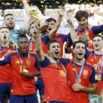Spain players celebrate with the FIFA World Cup trophy as golden confetti falls after the final victory.