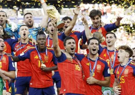Spain players celebrate with the FIFA World Cup trophy as golden confetti falls after the final victory.