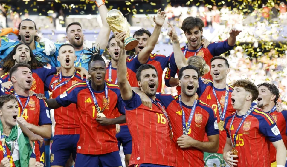 Spain players celebrate with the FIFA World Cup trophy as golden confetti falls after the final victory.