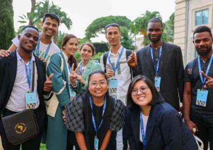 Youth delegates from diverse backgrounds gather outdoors during an international climate and sustainability event.