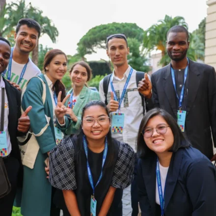 Youth delegates from diverse backgrounds gather outdoors during an international climate and sustainability event.