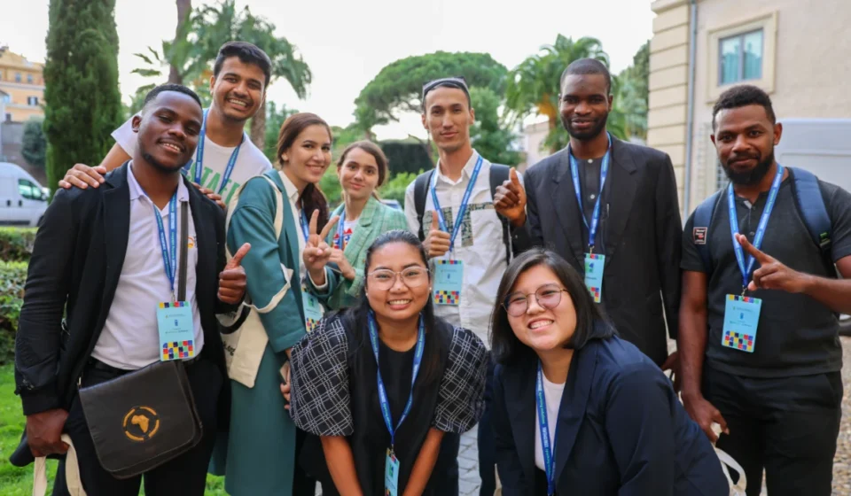 Youth delegates from diverse backgrounds gather outdoors during an international climate and sustainability event.