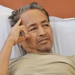 Man resting in a hospital bed during a hunger strike after police intervention over education protests.