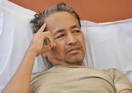 Man resting in a hospital bed during a hunger strike after police intervention over education protests.