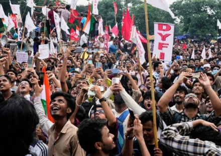 Crowds of students wave flags and record a large protest rally demanding education reforms across India.