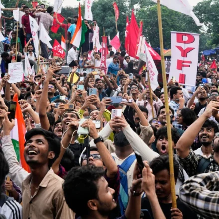 Crowds of students wave flags and record a large protest rally demanding education reforms across India.