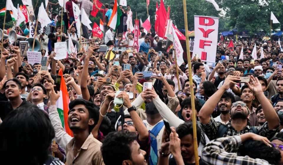 Crowds of students wave flags and record a large protest rally demanding education reforms across India.