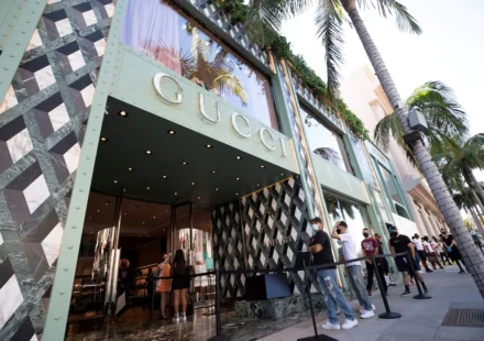 Gucci flagship store entrance with shoppers waiting outside, reflecting renewed luxury retail demand and growth.