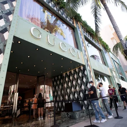 Gucci flagship store entrance with shoppers waiting outside, reflecting renewed luxury retail demand and growth.