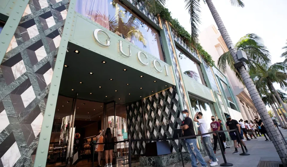Gucci flagship store entrance with shoppers waiting outside, reflecting renewed luxury retail demand and growth.