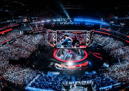 Packed esports arena with giant screens as fans watch an international gaming championship live.