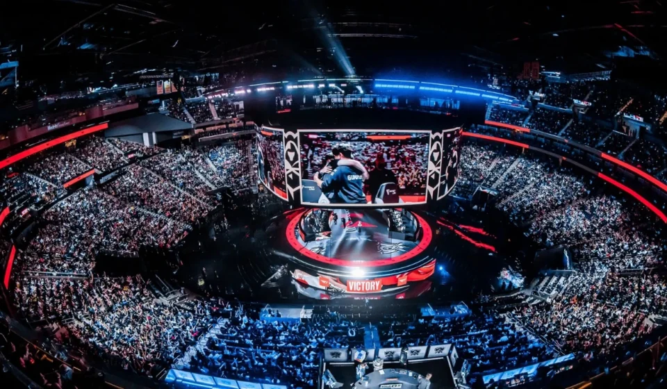 Packed esports arena with giant screens as fans watch an international gaming championship live.