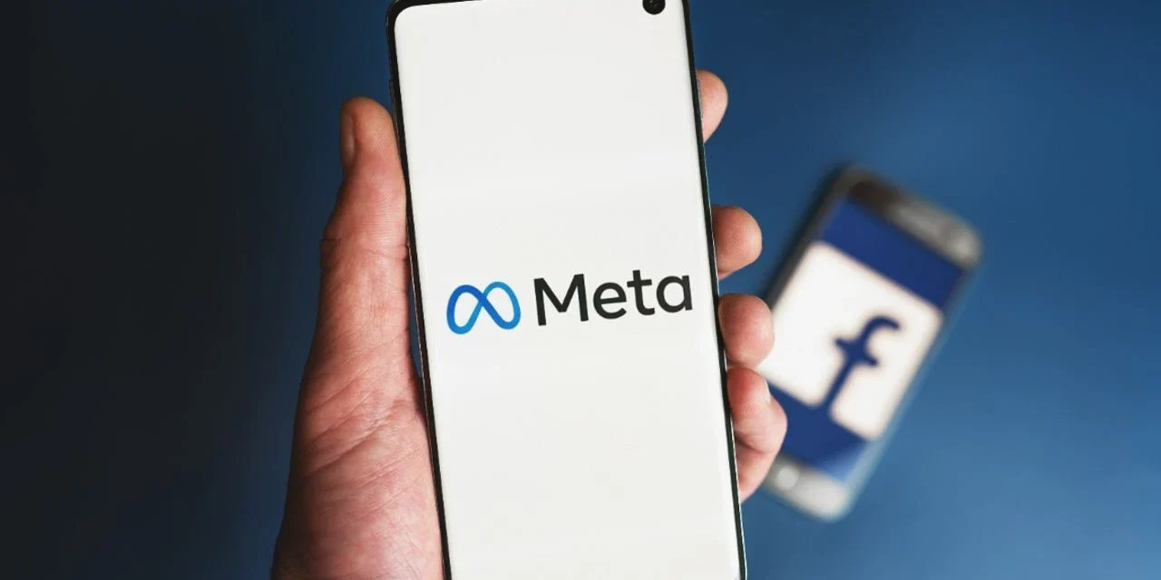 Meta logo displayed on a smartphone screen with a blurred Facebook logo in the background during lawsuit.