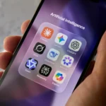 Hand holding smartphone displaying popular AI chatbot apps including ChatGPT, Gemini and Claude. app
