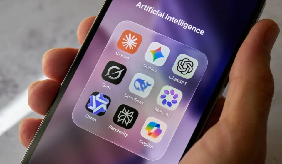 Hand holding smartphone displaying popular AI chatbot apps including ChatGPT, Gemini and Claude. app