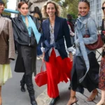 Fashion attendees showcase stylish streetwear outside the Paris Eco Fashion Summit during sustainability talks.