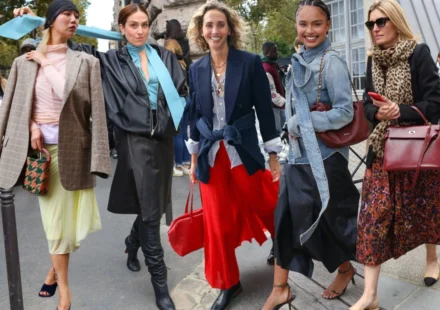 Fashion attendees showcase stylish streetwear outside the Paris Eco Fashion Summit during sustainability talks.
