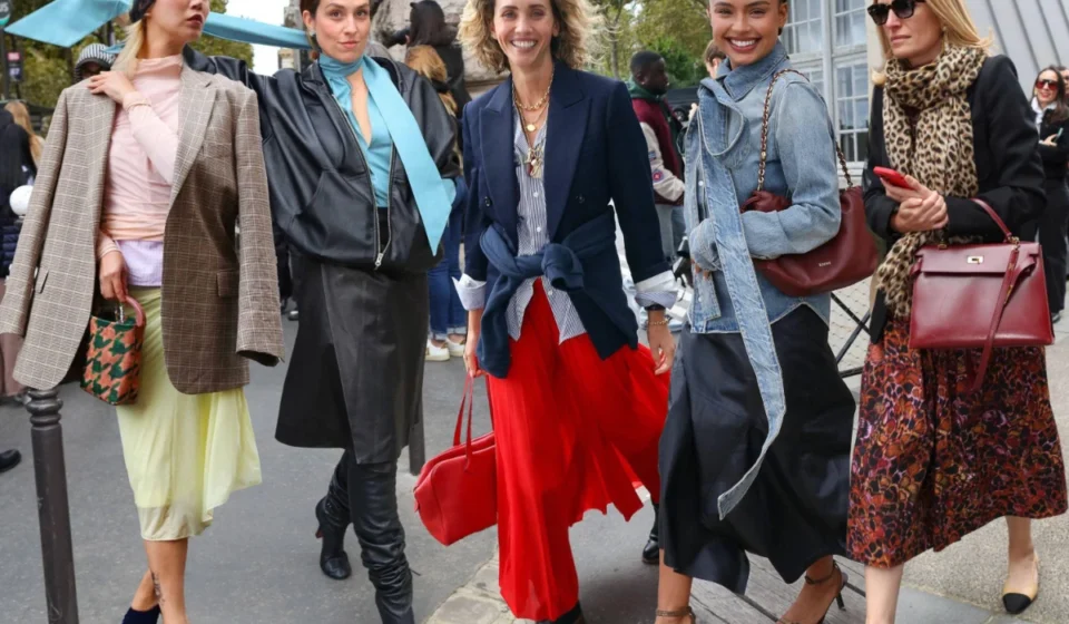 Fashion attendees showcase stylish streetwear outside the Paris Eco Fashion Summit during sustainability talks.