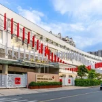 Canadian International School campus building in Vietnam with modern architecture and flags lining entrance road.