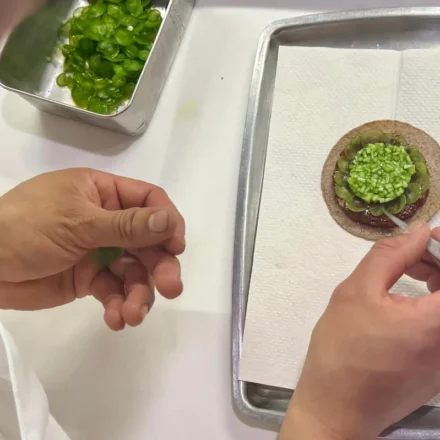 Chef carefully plating an elegant Mexican fine dining dish before service at a Michelin star restaurant.