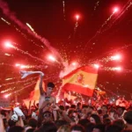 Crowds wave Spanish flags beneath fireworks as Madrid celebrates world title victory together. joy!!