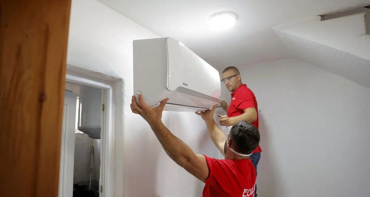 Technicians install a wall mounted smart air conditioner in a home to improve energy efficient cooling during heatwaves.