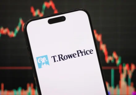 Smartphone displaying T. Rowe Price logo with cryptocurrency market chart blurred behind on screen.