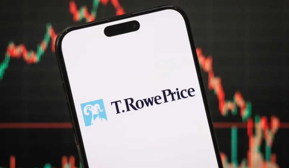 Smartphone displaying T. Rowe Price logo with cryptocurrency market chart blurred behind on screen.