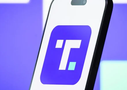 Smartphone displaying Trump Media app logo on purple background illustrating premium social platform