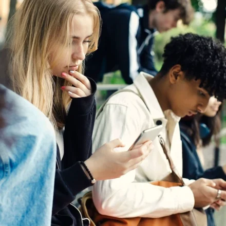 Teenagers using smartphones outdoors as UK proposes voluntary overnight social media curfew at night