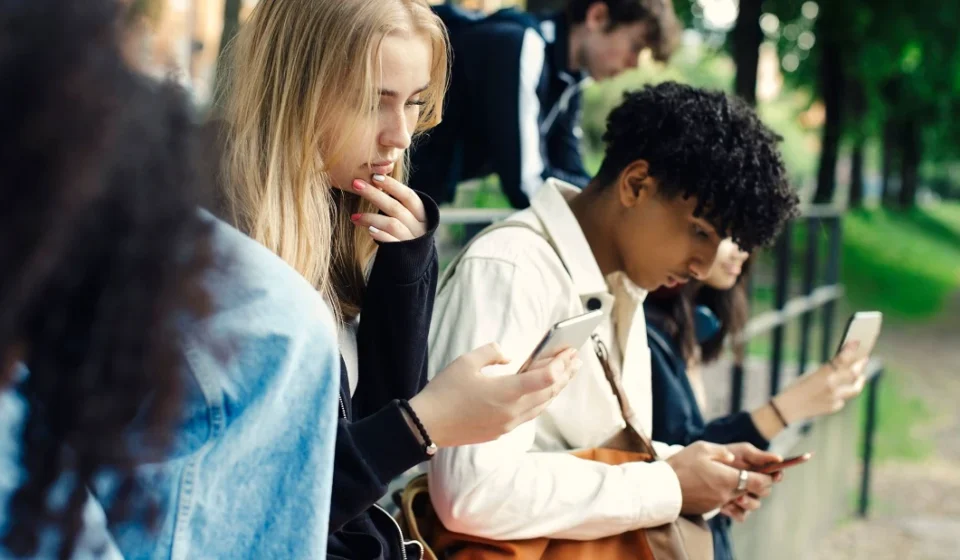 Teenagers using smartphones outdoors as UK proposes voluntary overnight social media curfew at night