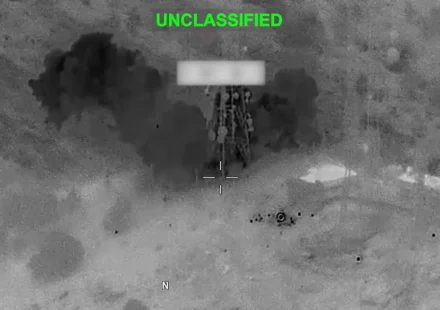 Thermal aerial view shows explosion near a military target during nighttime strike in Middle East.