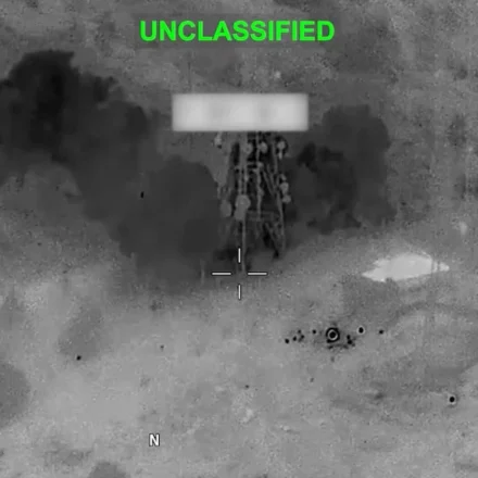 Thermal aerial view shows explosion near a military target during nighttime strike in Middle East.