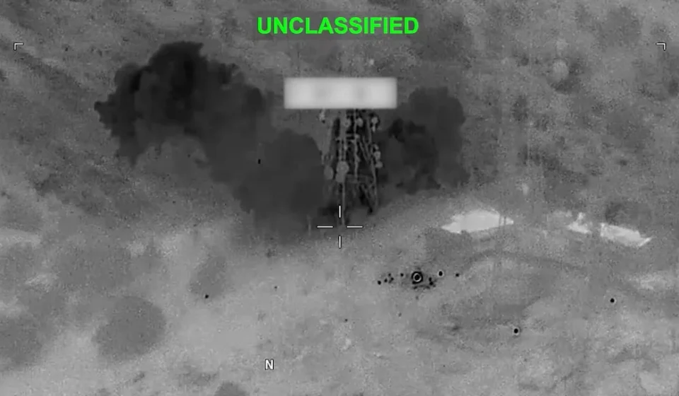 Thermal aerial view shows explosion near a military target during nighttime strike in Middle East.