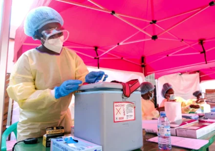 Healthcare worker handles medical supplies at an Ebola response site as Uganda officially ends outbreak control.