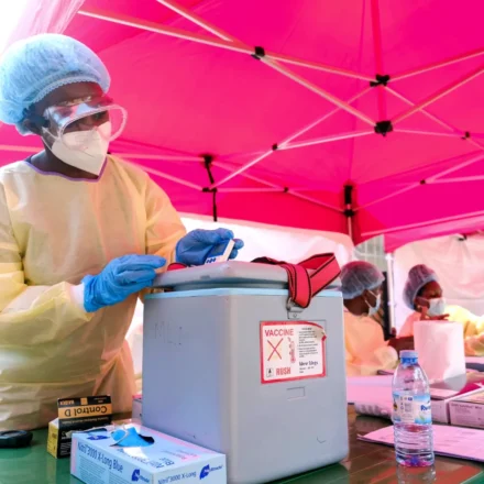 Healthcare worker handles medical supplies at an Ebola response site as Uganda officially ends outbreak control.