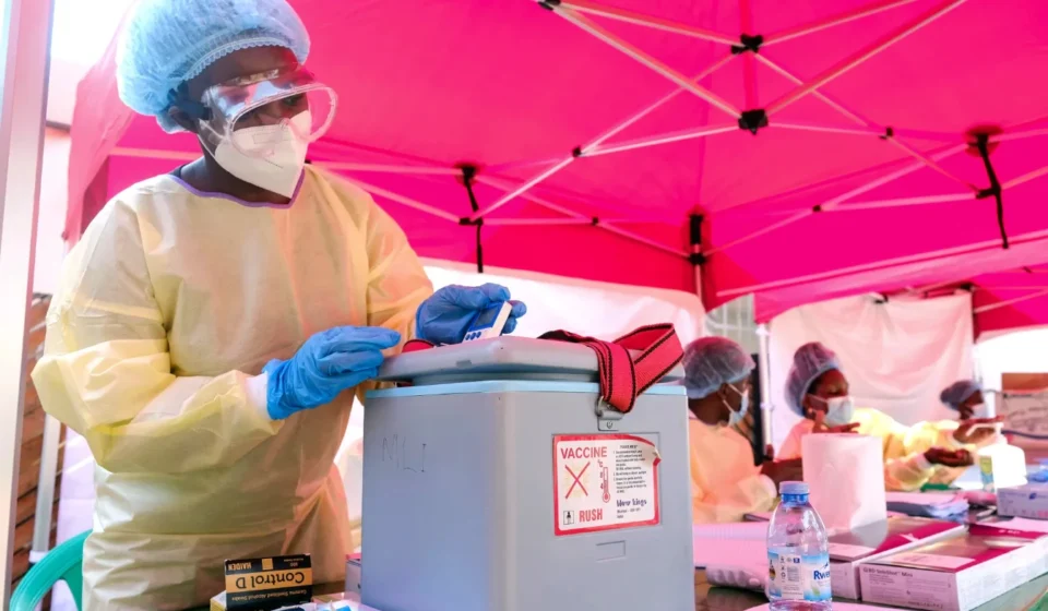 Healthcare worker handles medical supplies at an Ebola response site as Uganda officially ends outbreak control.