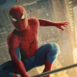 Spider Man crouches above a city skyline at sunset, ready for action in his iconic red and blue suit.
