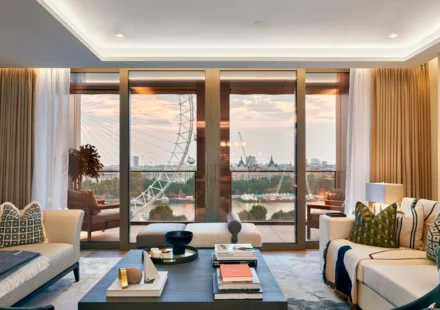 Modern living room with layered lighting, floor to ceiling windows and natural daylight inside.