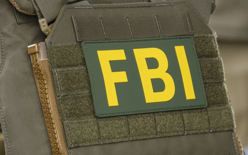 Close up of FBI patch on tactical vest during federal crypto investigation linked to alleged theft.