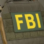 Close up of FBI patch on tactical vest during federal crypto investigation linked to alleged theft.