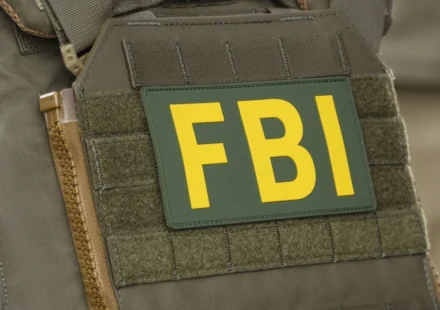 Close up of FBI patch on tactical vest during federal crypto investigation linked to alleged theft.